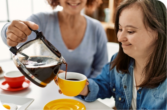 healthcare worker pouring coffee for disabled woman