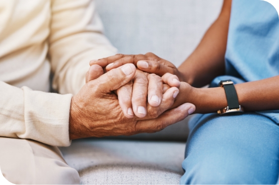 healthcare worker and elderly woman embracing hands