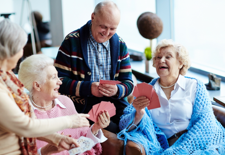 group of elderly people playing cards